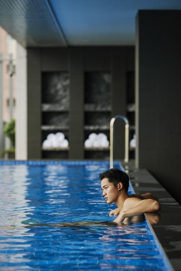 Silks Club Hotel Kaohsziung Kültér fotó A man swimming in a pool